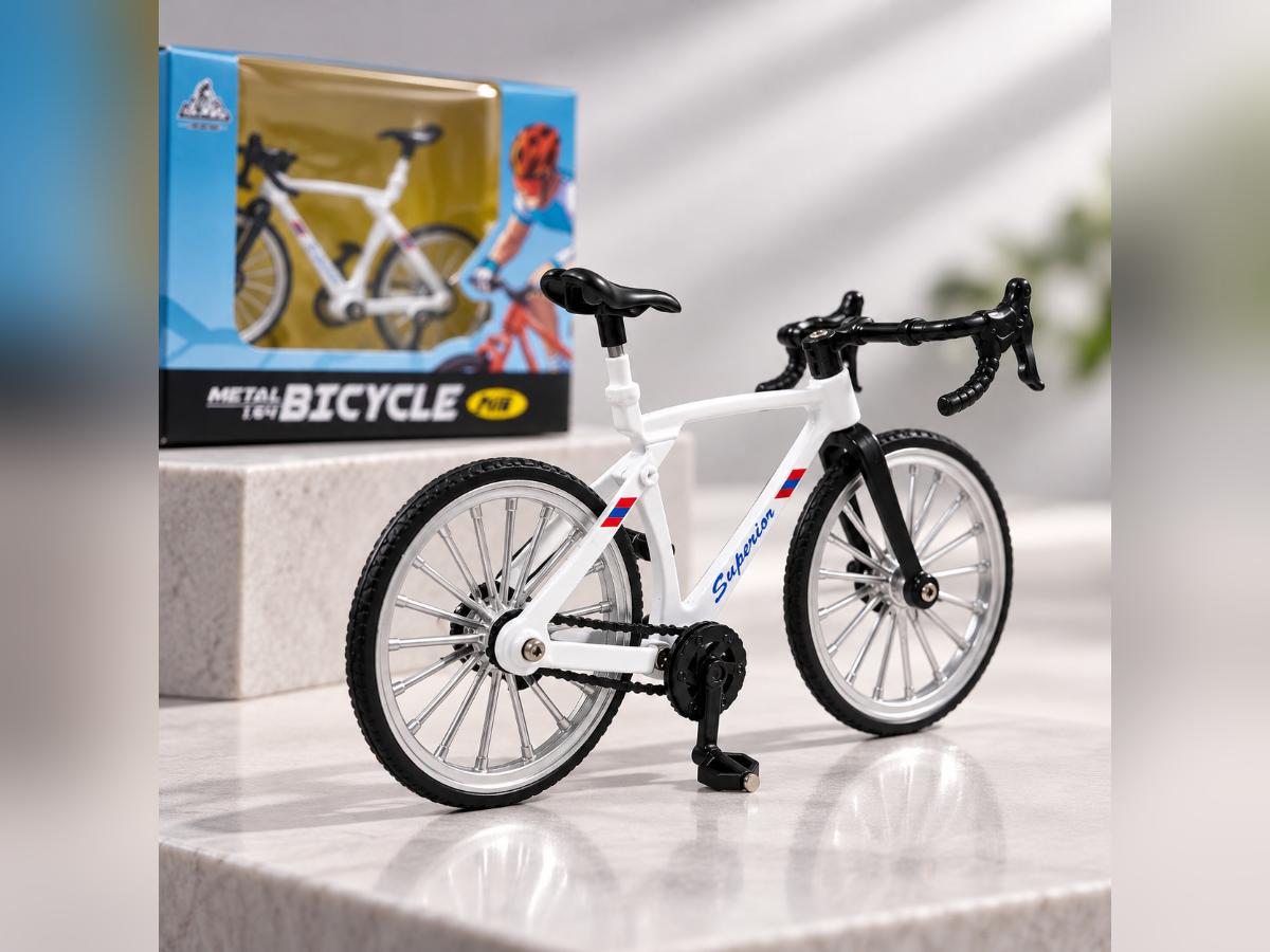 White miniature road bicycle displayed on a stone surface beside its retail packaging